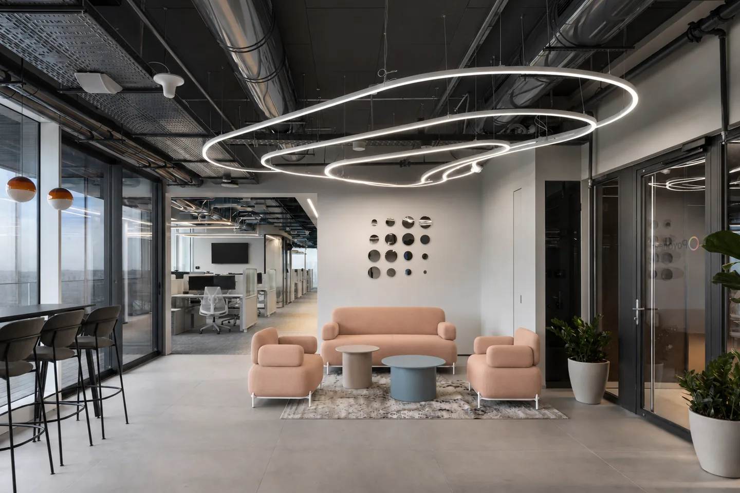 Cove lounge seating beneath a sculptural ring pendant in an open workspace